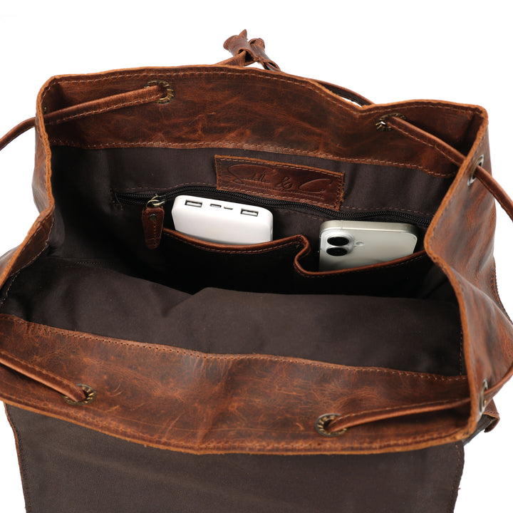 Brown leather bag with interior compartments and phone inside on a white background