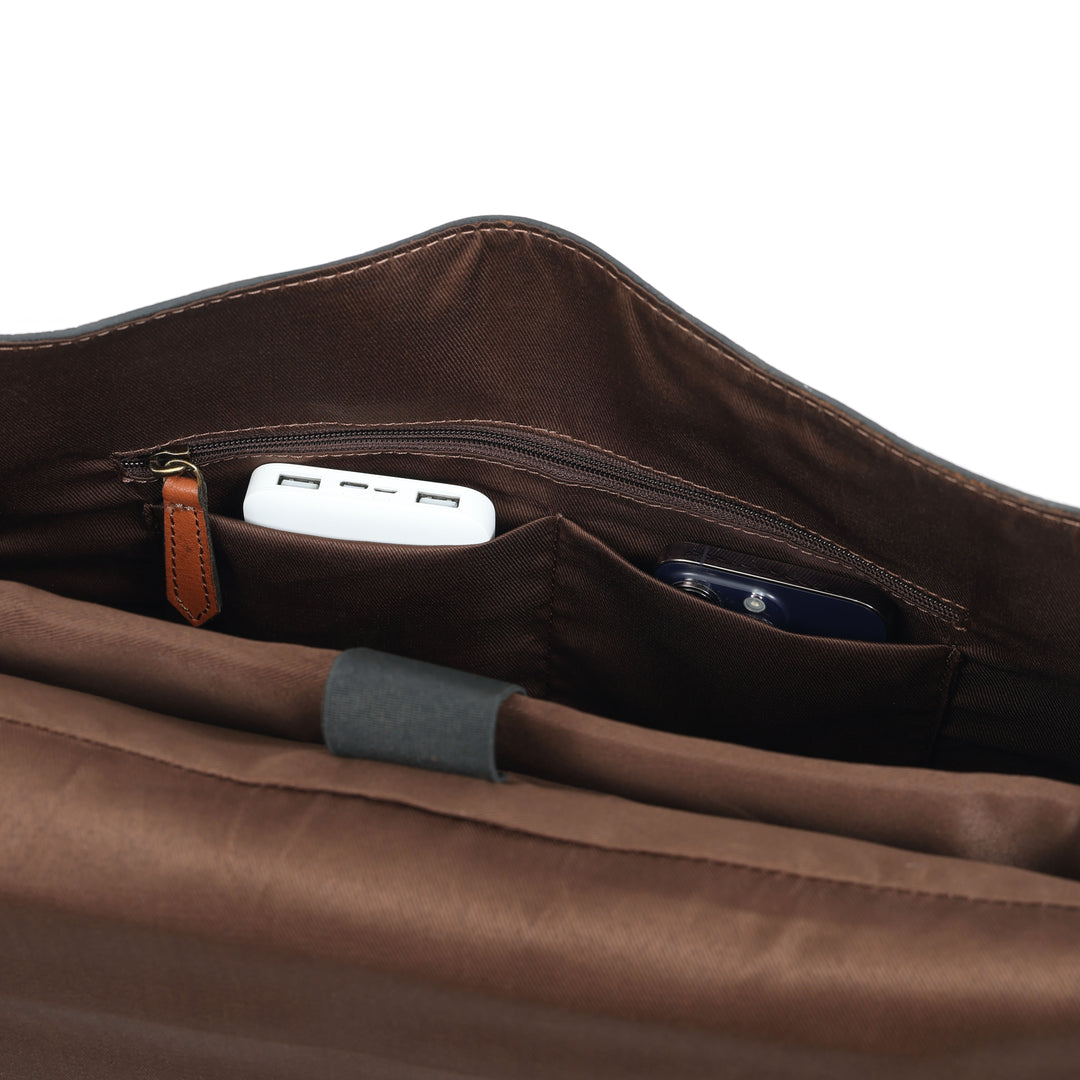Brown leather bag with a USB drive and smartphone inside on a white background