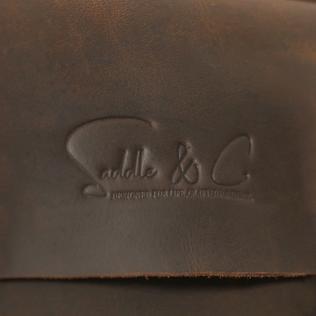 Close-up of a brown leather surface with an embossed logo and text.