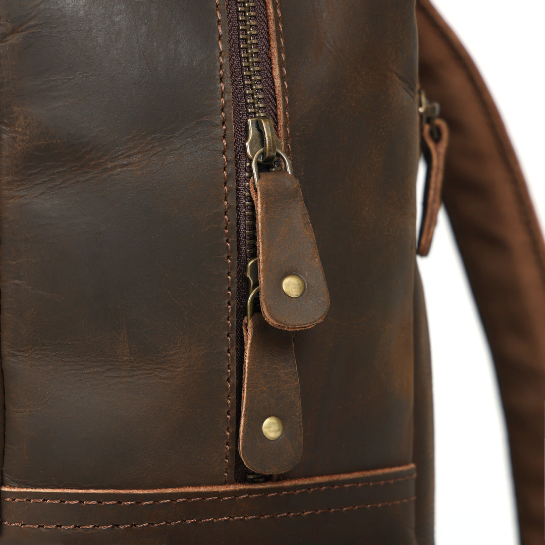 Close-up of a brown leather bag with stitching details on a white background