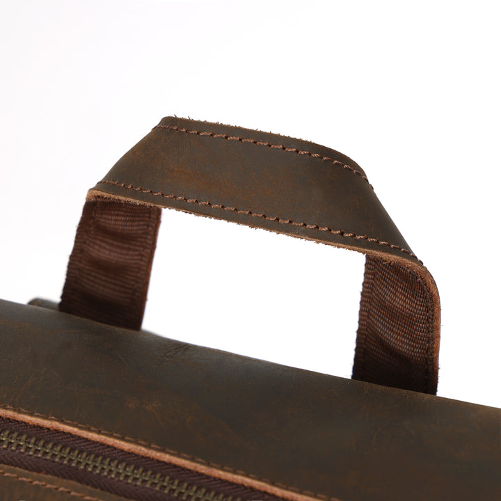 Close-up of a brown leather bag with a handle on a white background