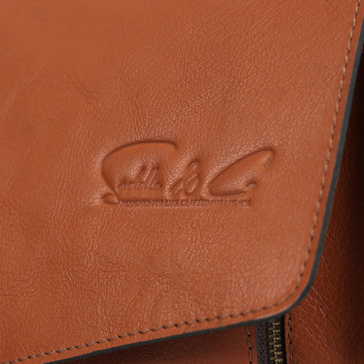 Close-up of a brown leather product with a visible brand logo.