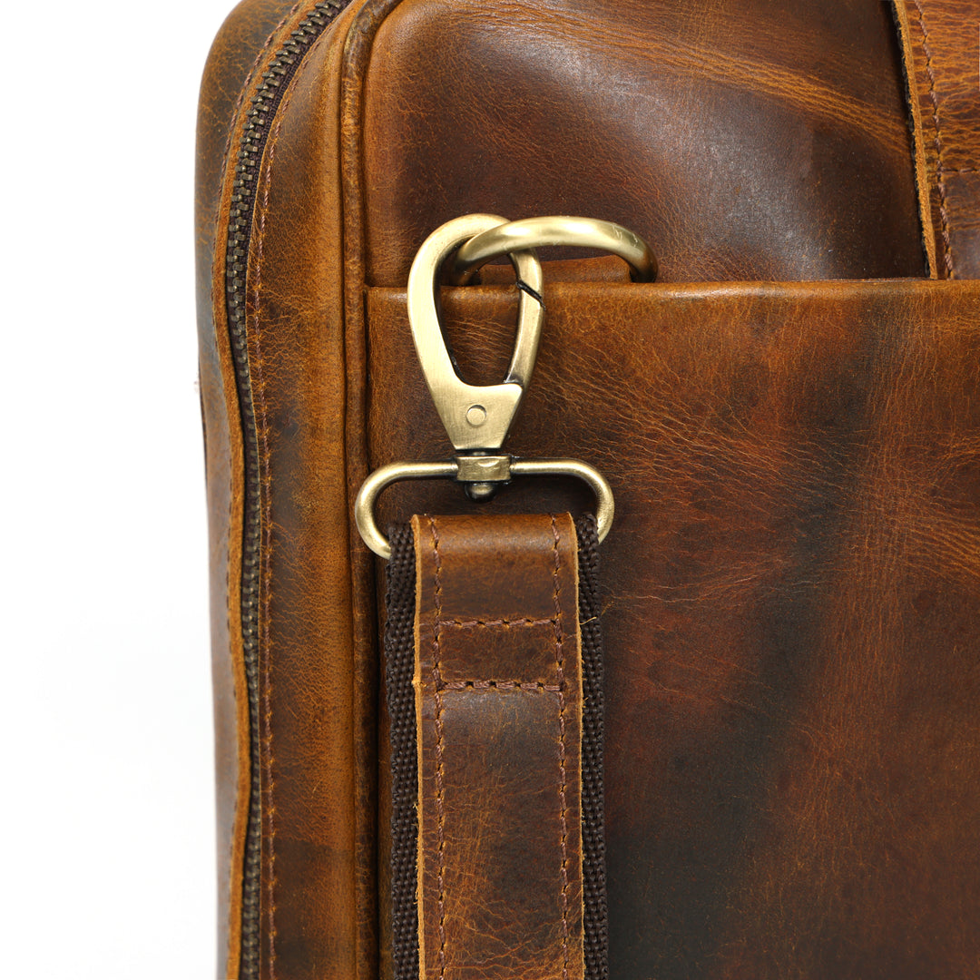 Close-up of a brown leather bag with a gold clasp on a white background