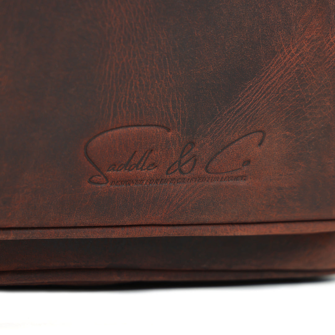 Close-up of a brown leather product with 'Saddle & Co.' branding.