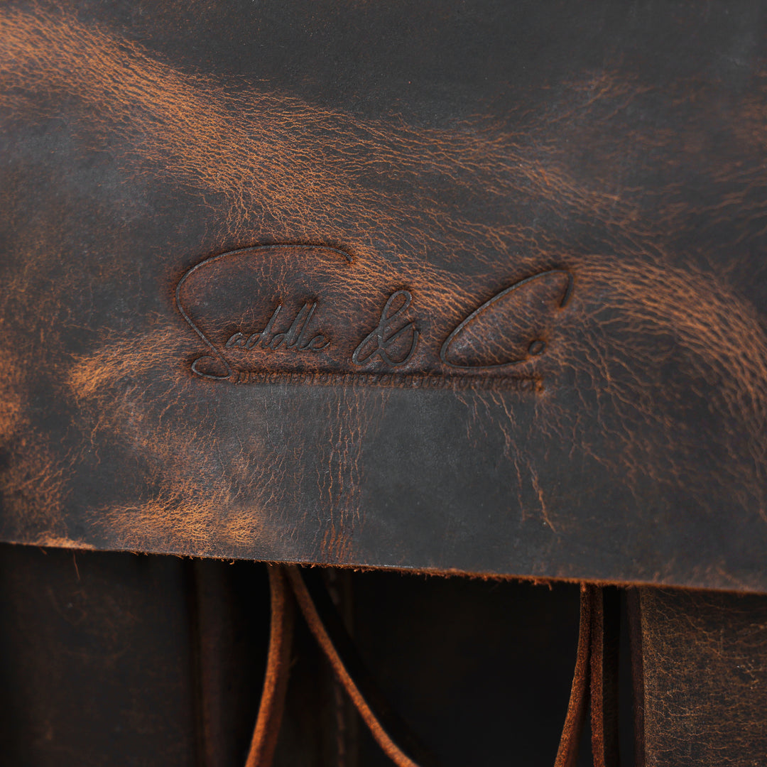 Close-up of a brown leather bag with an embossed brand logo.