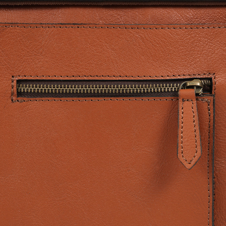 Close-up of a brown leather bag with a zipper
