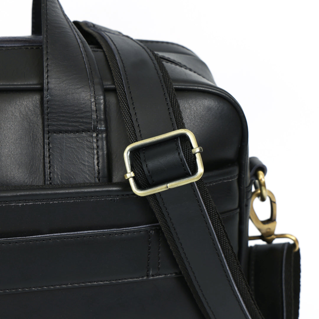 Black leather bag with gold buckle and clasp on a white background