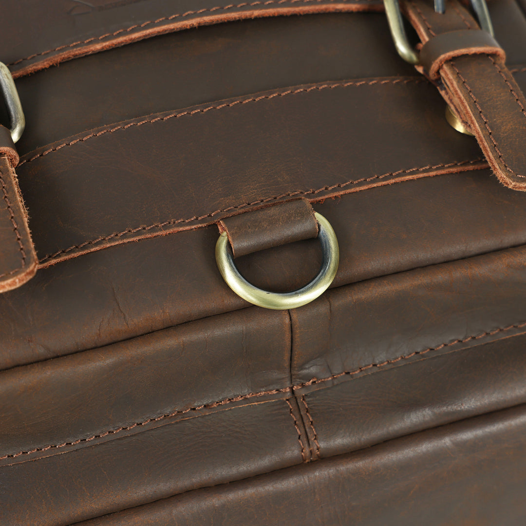 Close-up of a brown leather bag with a gold metal ring.