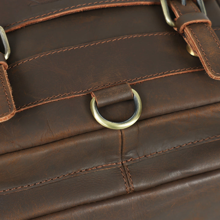 Close-up of a brown leather bag with a gold metal ring.