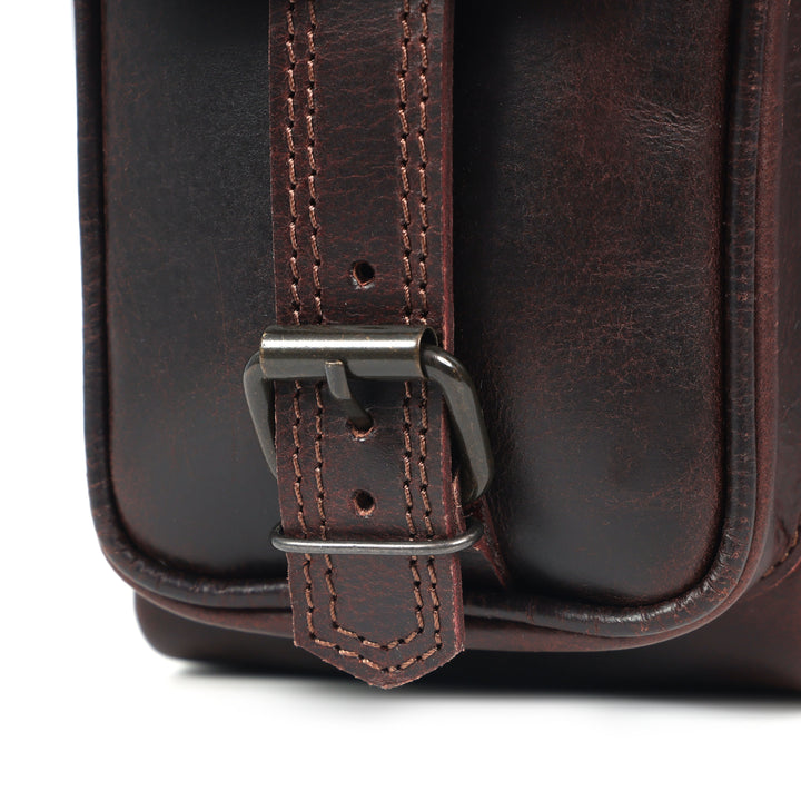 Close-up of a brown leather bag with a buckle on a white background