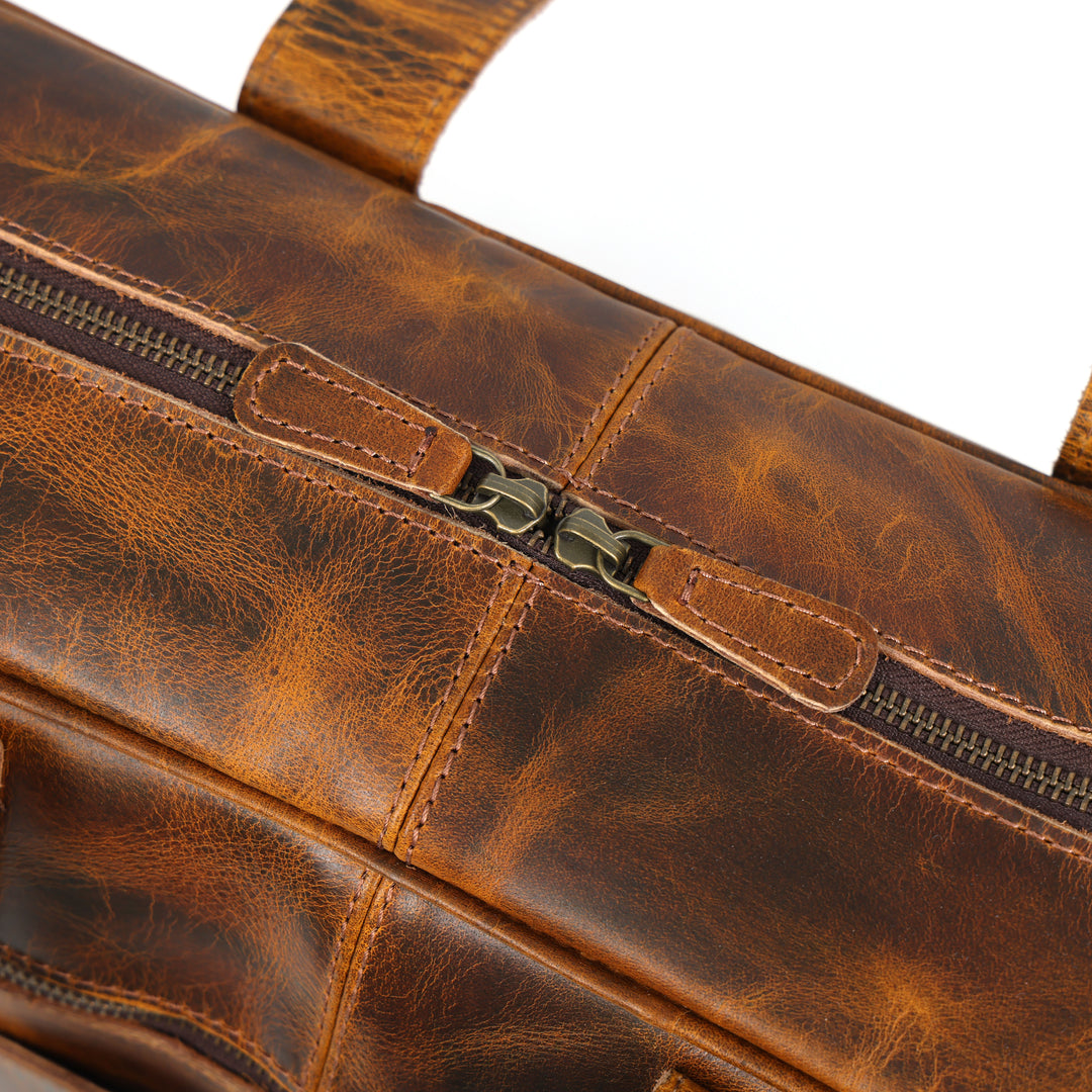 Close-up of a brown leather bag with visible stitching and zipper.