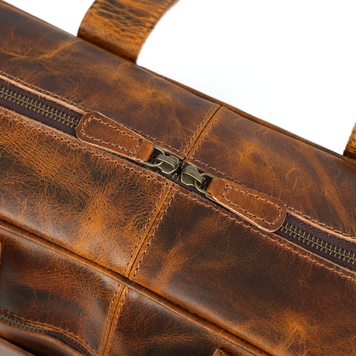 Close-up of a brown leather bag with visible stitching and zipper.