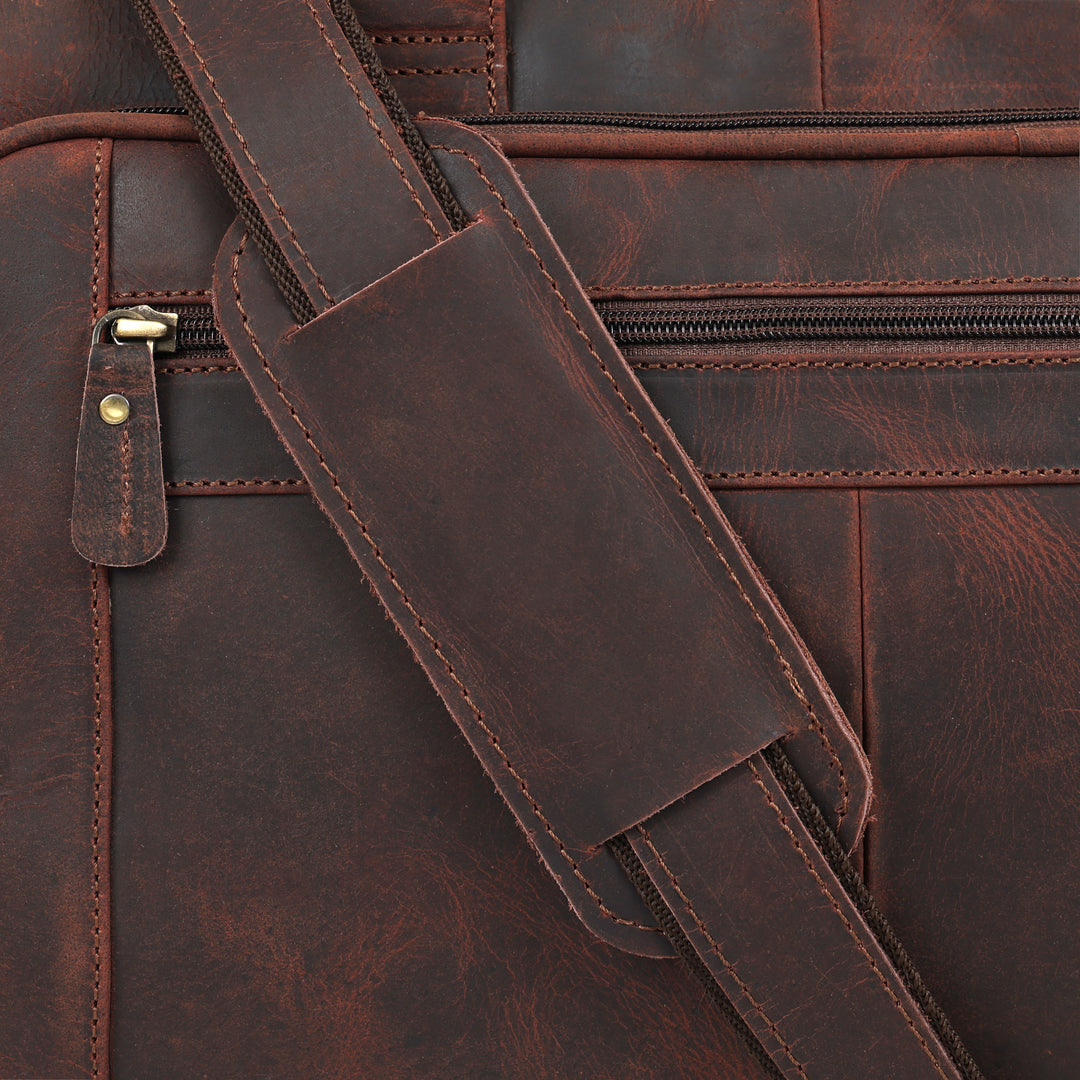 Close-up of a brown leather bag with a strap and zipper