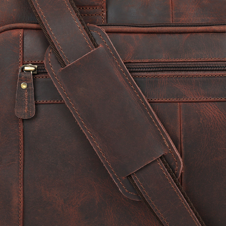Close-up of a brown leather bag with a strap and zipper