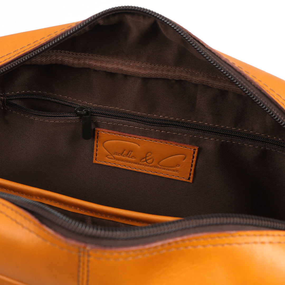 Close-up of a brown leather bag with a visible brand label on a white background