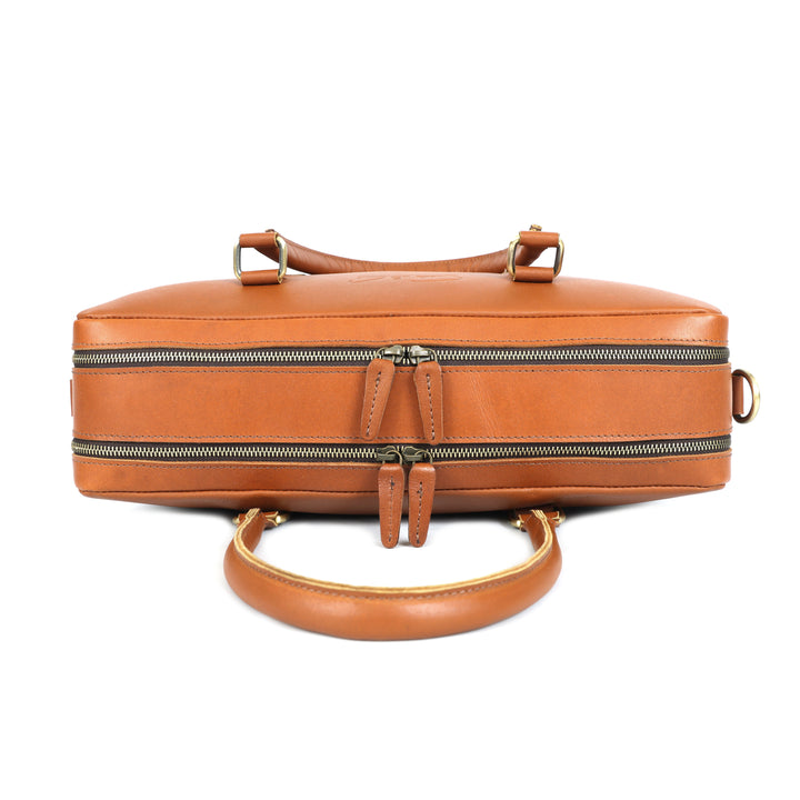 Brown leather handbag with gold accents on a white background