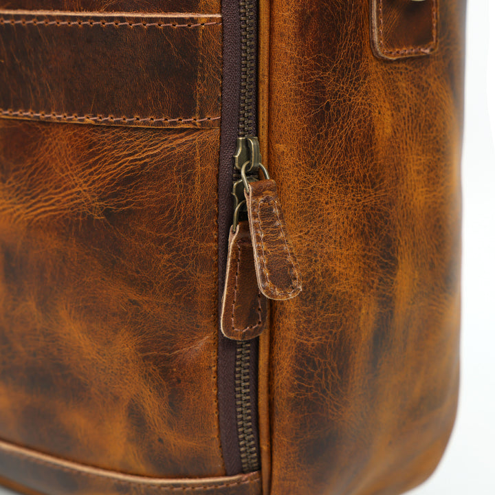 Close-up of a brown leather bag with a zipper