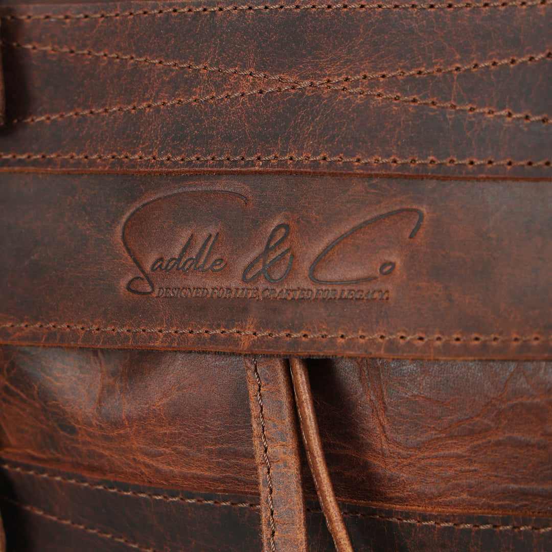 Close-up of a brown leather product with 'Saddle & Co.' branding.