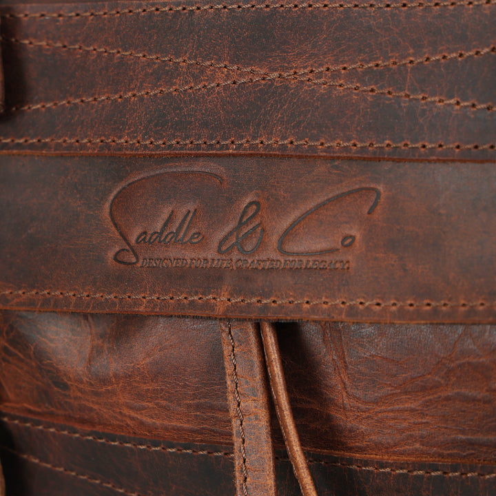 Close-up of a brown leather product with 'Saddle & Co.' branding.