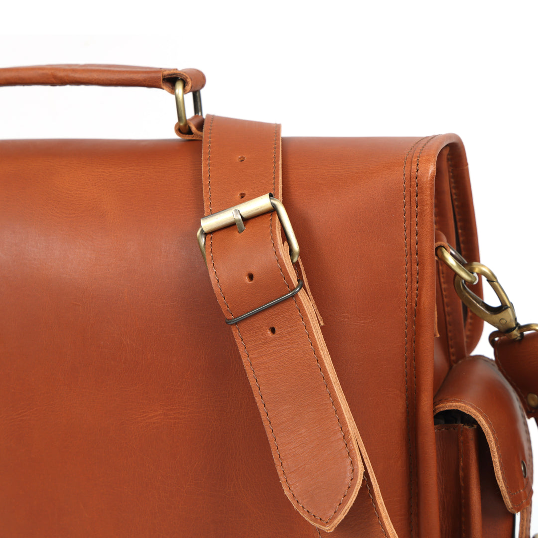 Brown leather satchel with gold buckle on a white background