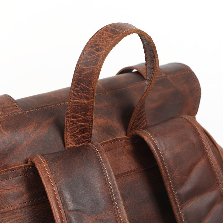 Close-up of a brown leather bag with handle on a white background