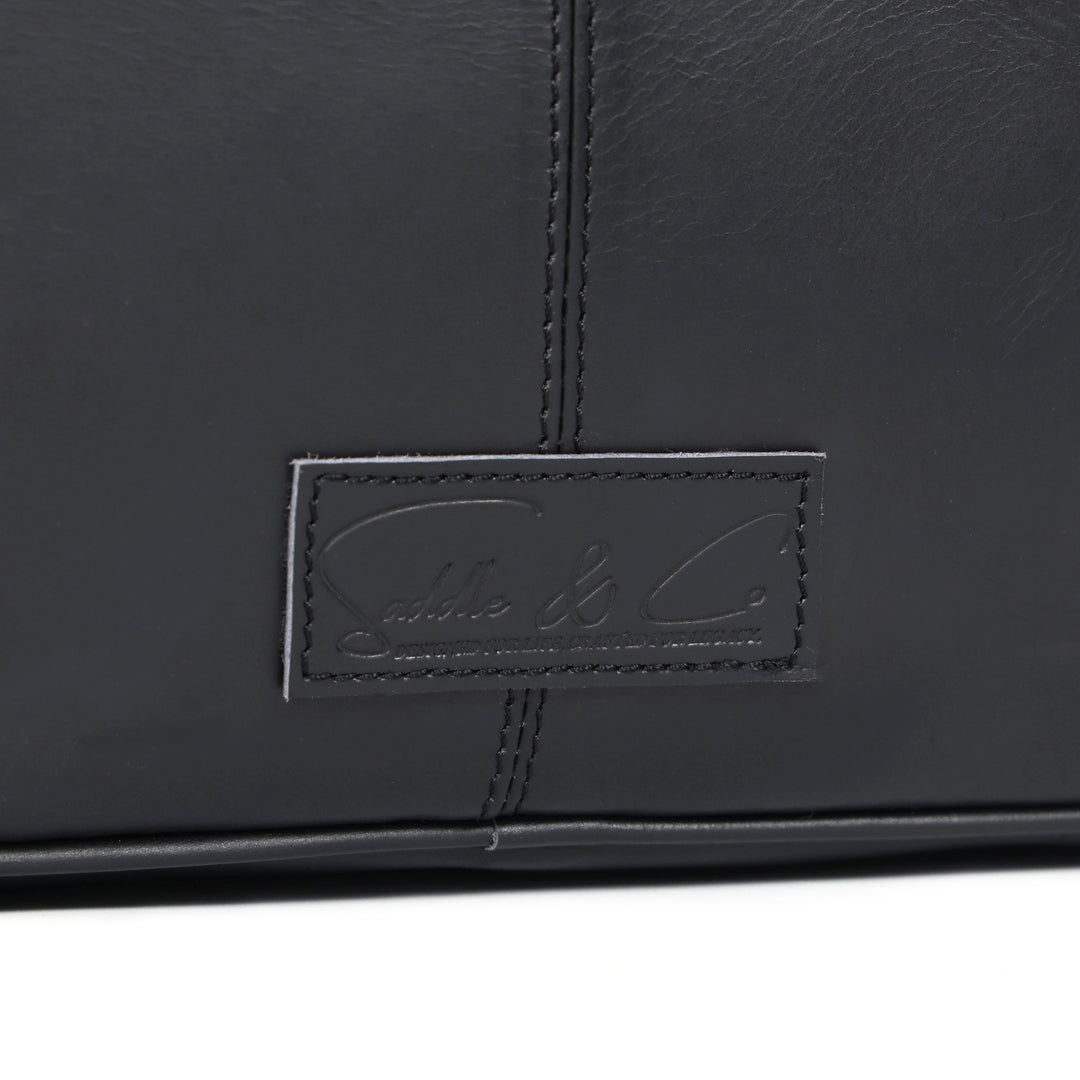 Close-up of a black leather product with a brand logo on a white background