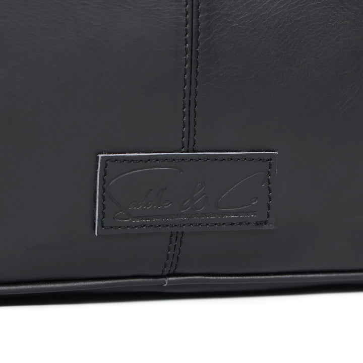 Close-up of a black leather product with a brand logo on a white background