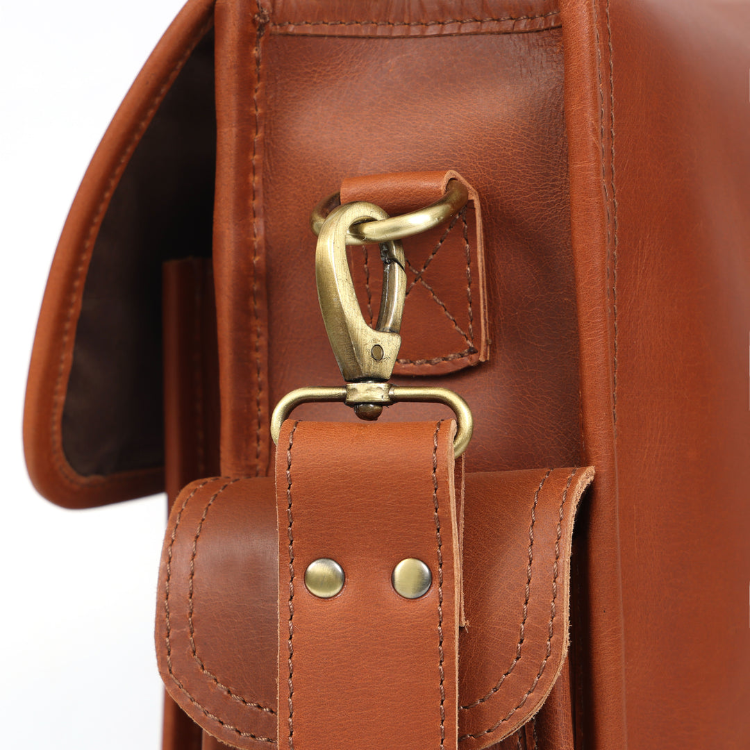 Close-up of a brown leather bag with a gold clasp on a white background