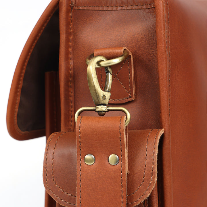 Close-up of a brown leather bag with a gold clasp on a white background