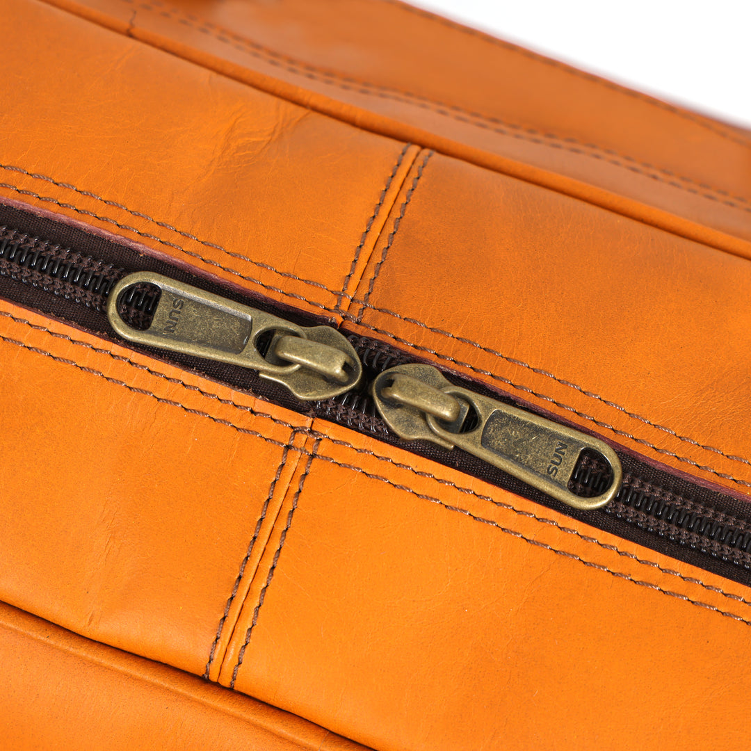 Close-up of an orange leather bag with a zipper