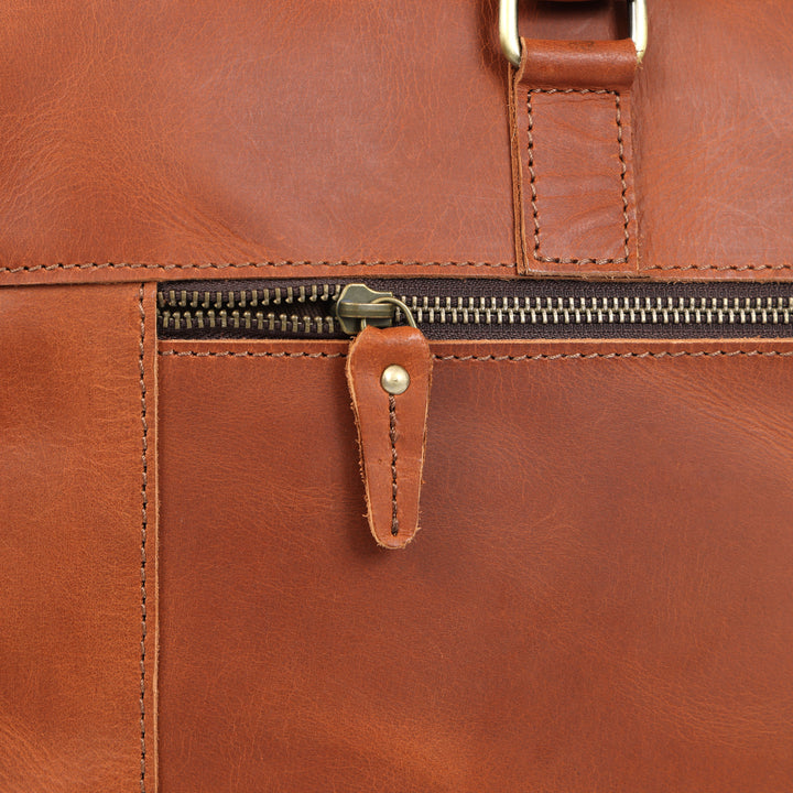Close-up of a brown leather bag with a zipper