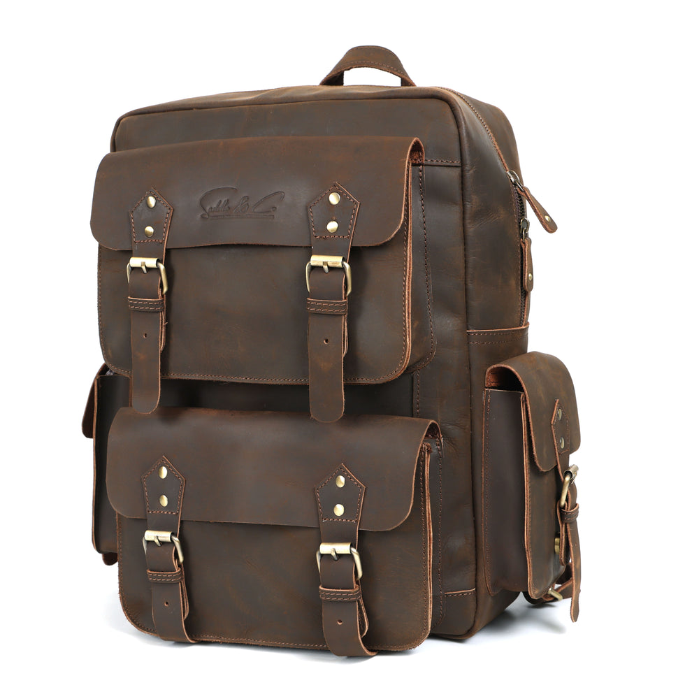 Brown leather backpack with gold buckles on a white background