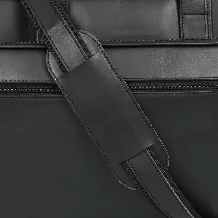 Close-up of a black leather bag with a strap