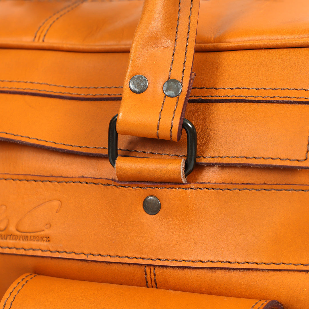 Close-up of a brown leather bag with visible stitching and brand logo.