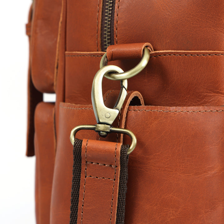 Close-up of a brown leather bag with a gold clasp on a white background