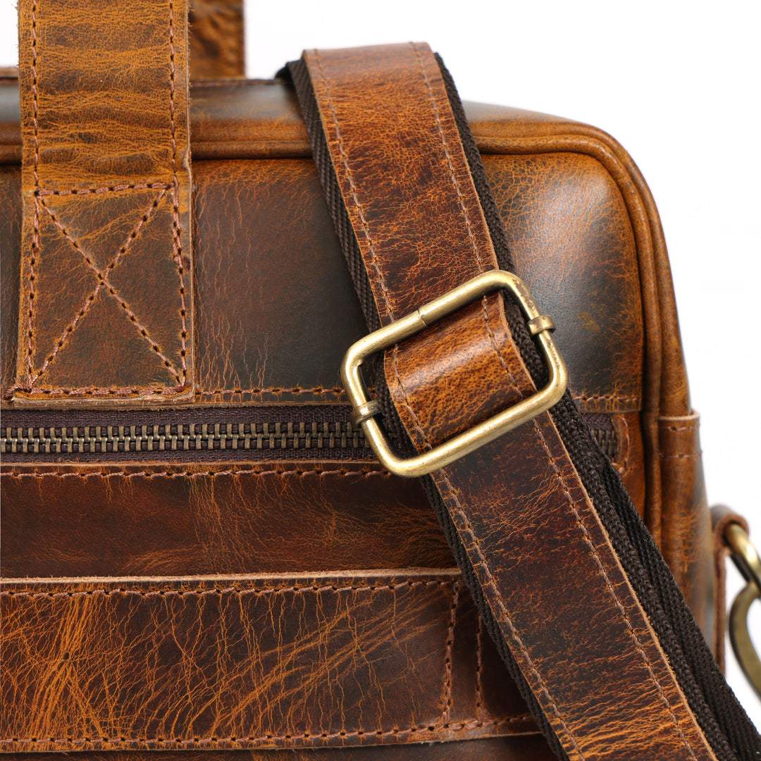 Close-up of a brown leather bag with a gold buckle on a white background