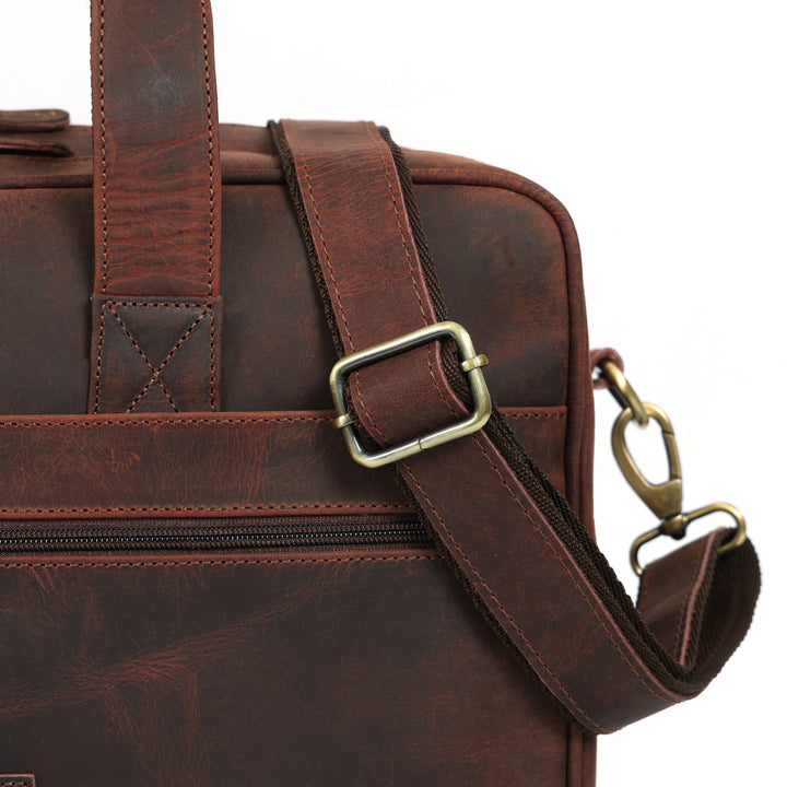 Brown leather bag with gold buckle and clasp on a white background