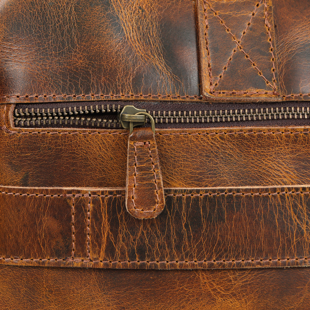 Close-up of a brown leather bag with a zipper