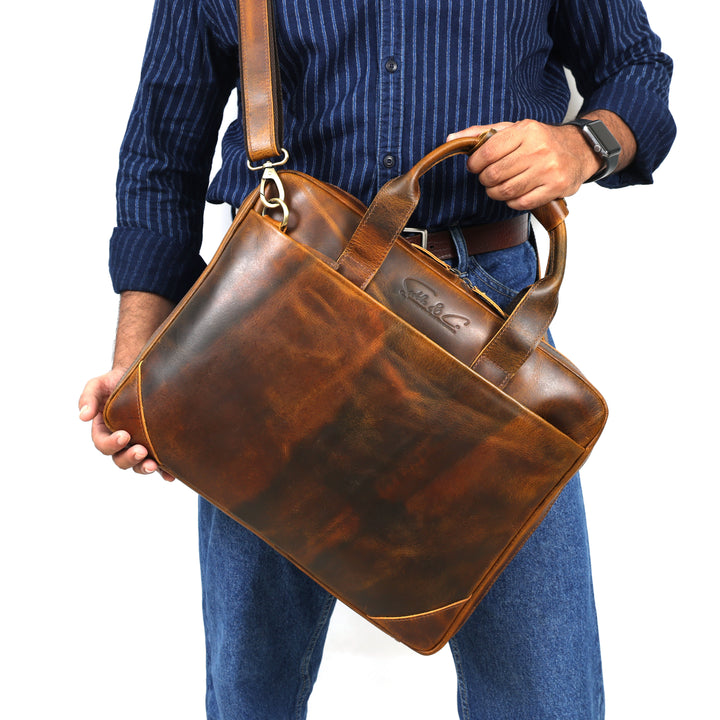 Person holding a brown leather briefcase against a white background
