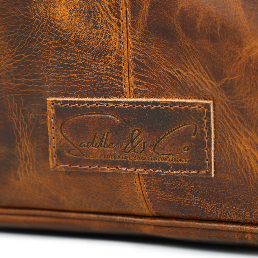 Close-up of a brown leather bag with a visible brand logo.