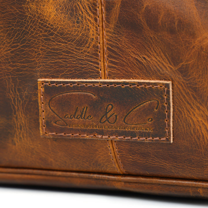 Close-up of a brown leather bag with a visible brand logo.