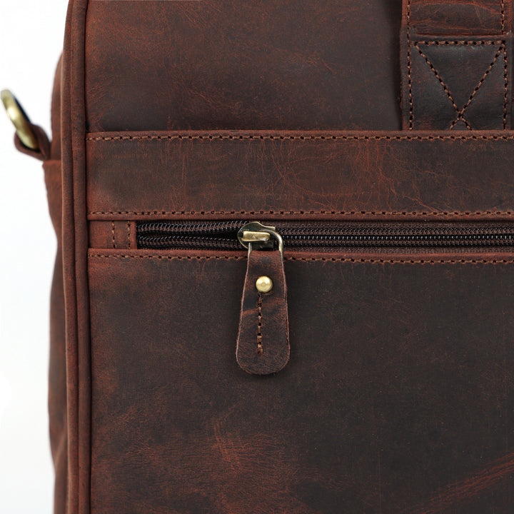 Close-up of a brown leather bag with a zipper