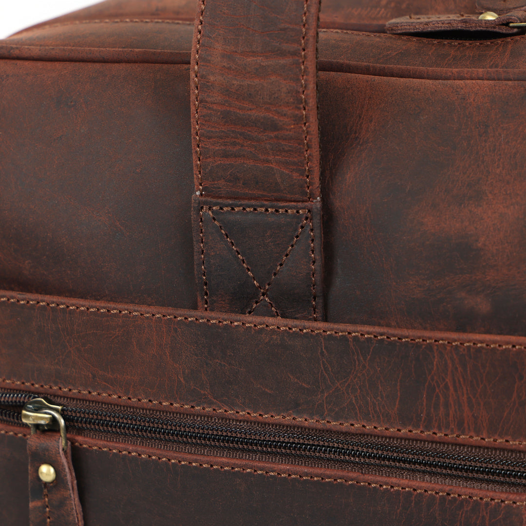 Close-up of a brown leather bag with visible stitching and zipper.