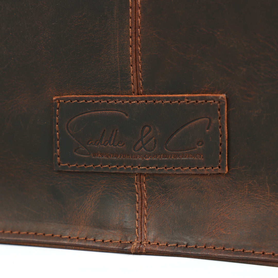 Close-up of a brown leather bag with a brand logo on a white background
