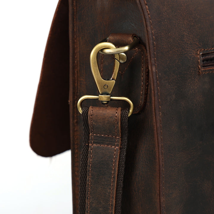 Close-up of a brown leather bag with a gold clasp on a white background