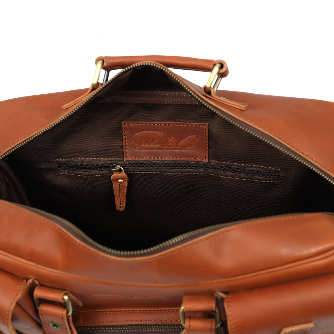 Brown leather bag with gold hardware on a white background
