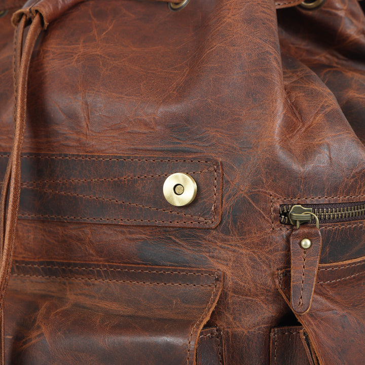 Close-up of a brown leather bag with brass hardware