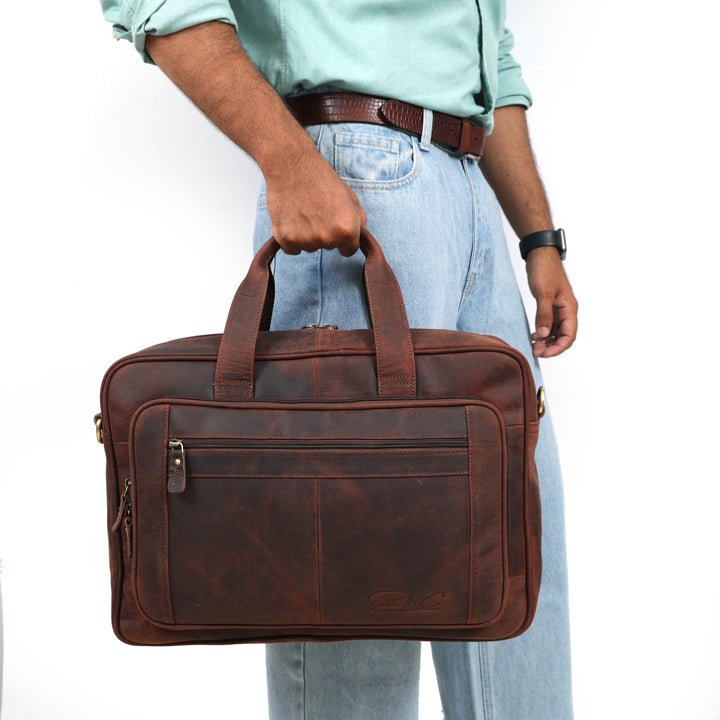 Person holding a brown leather briefcase against a white background