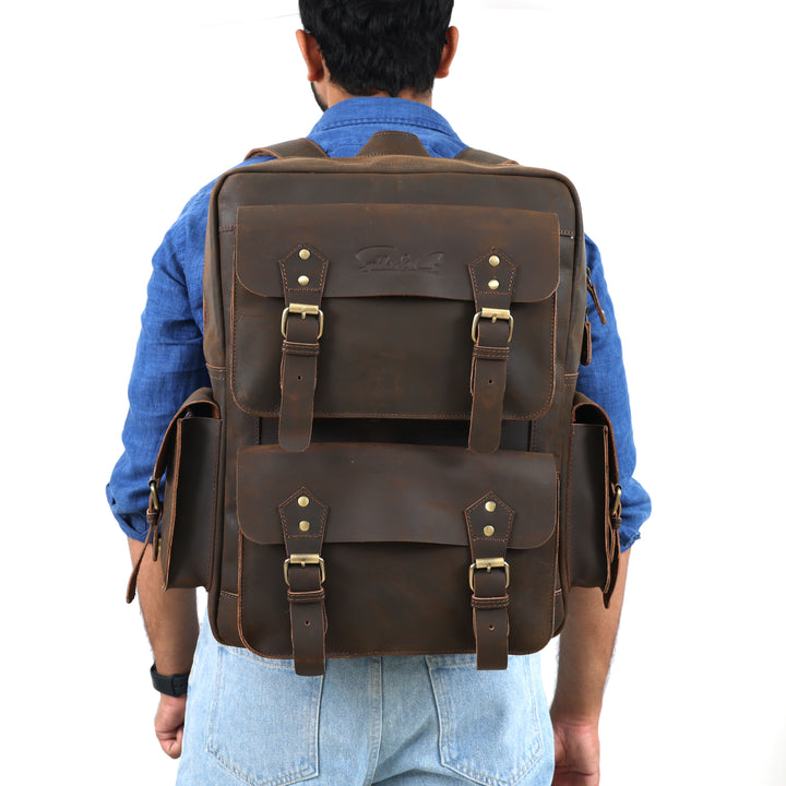 Man wearing a large brown leather backpack on a white background