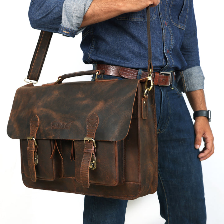 Man holding a brown leather satchel bag against a white background